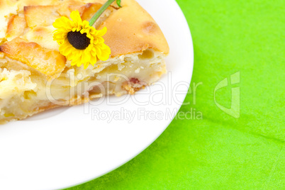 piece of apple pie and a flower lying on the green cloth