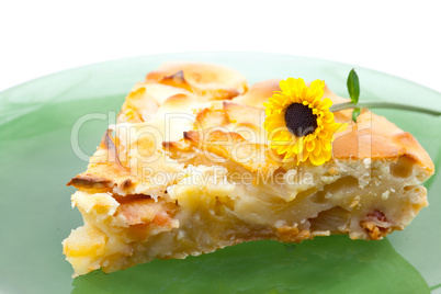 piece of apple pie on a plate and a flower isolated on white