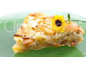 piece of apple pie on a plate and a flower isolated on white