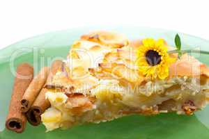piece of apple pie on a plate and a flower isolated on white