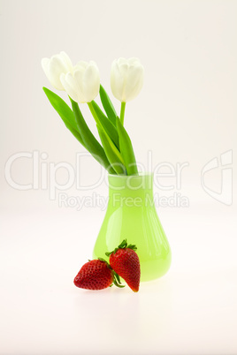 vase with tulips and strawberries isolated on white