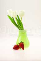 vase with tulips and strawberries isolated on white