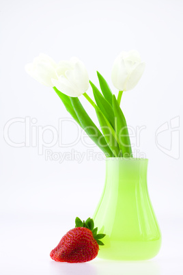 white tulips in a vase and strawberries isolated on white