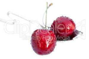 cherries with drops of water in the spoon isolated on white