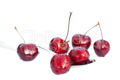 cherries with drops of water in the spoon isolated on white