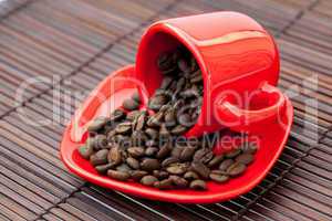 red cup with coffee beans on a bamboo mat