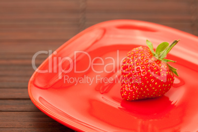 strawberries in a saucer on a bamboo mat