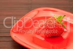 strawberries in a saucer on a bamboo mat