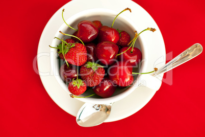 cup, saucer and spoon  on a red background