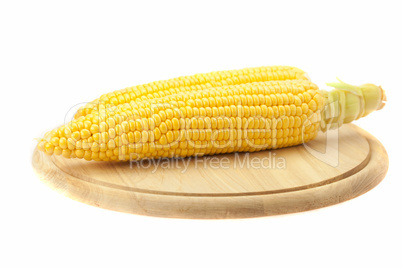 Corn lying on a cutting board isolated on white