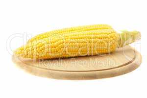 Corn lying on a cutting board isolated on white