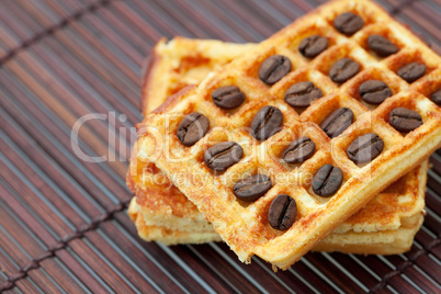 waffles and coffee beans on a bamboo mat