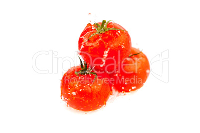 tomatoes with splashes of water isolated on white