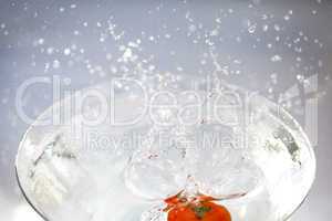 tomatoes with splashes of water in a glass bowl