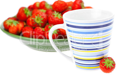 cup and saucer with strawberries isolated on white