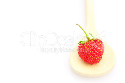 Strawberries in wooden spoon isolated on white