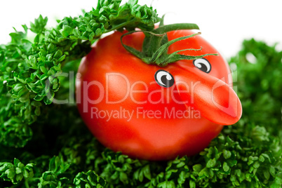 tomato with eyes lying on a plate with greens