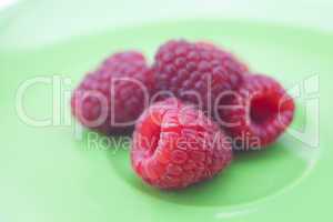 raspberries lying on a green plate