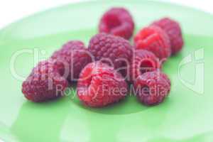 raspberries lying on a green plate