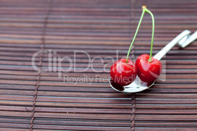 cherry in a spoon on a bamboo mat