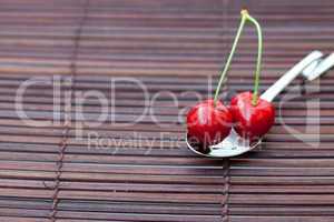 cherry in a spoon on a bamboo mat