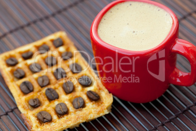 coffee beans, waffles and cappuccino on a bamboo mat