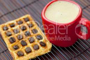 coffee beans, waffles and cappuccino on a bamboo mat
