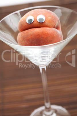 Peach with eyes in the glass martini on a bamboo mat