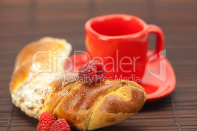 Cup with a plate , raspberry and roll on a bamboo mat