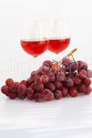 glass of wine and a bunch of grapes isolated on white