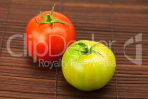 green and red tomatoes on a bamboo mat