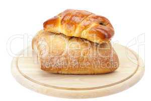 bread and loaf with poppy seeds on a cutting board isolated on w