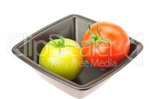 green and red tomatoes in a bowl isolated on white
