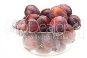 plums in a glass bowl isolated on white