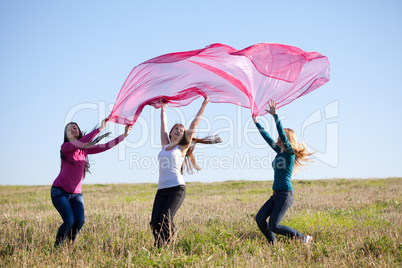 beautiful teenager woman jumping with a thin tissue outdoor