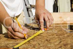 Worker Measuring Plywood