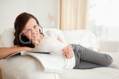 Young woman studying on the sofa looking into the camera