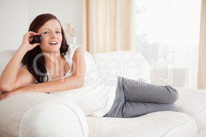 Smiling red-haired woman on the phone relaxing on a sofa Smiling red-haired woman on the phone relaxing on a sofa