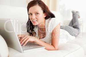 Relaxed red-haired woman searching the internet looking into the