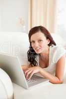 Relaxed red-haired woman with laptop looking into the camera