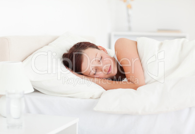 Beautiful Red-haired woman lying in bed sleeping