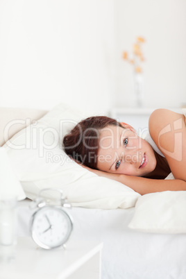 Close up of a Red-haired woman lying in bed looking into the cam