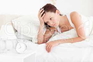 Tired red-haired woman waking up