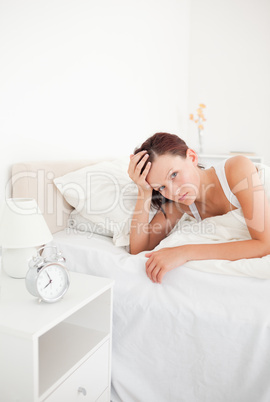 Cute red-haired woman waking up looking into the camera