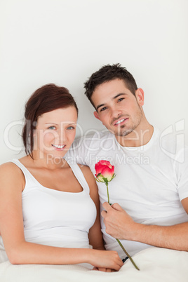 Happy couple with a rose looking at the camera