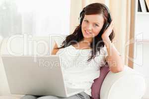 Young woman listening to music looking into camera