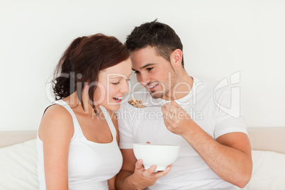 Man feeding cereal to his wife