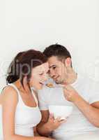 Close up of a man feeding cereal to his wife