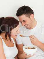 Portrait of a man feeding cereal to his wife