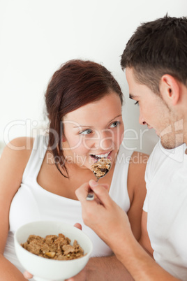 Portrait of a woman fed with cereal by her man